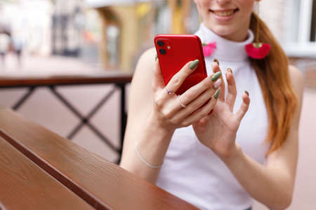a woman smiles at the phone in the summer. blog. close up