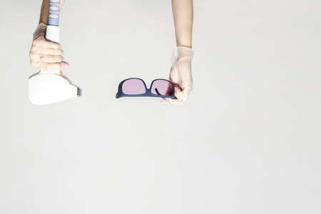 Diode laser hair removal and protective glasses on a white background. body hair laser hair removal. no peopleの写真素材