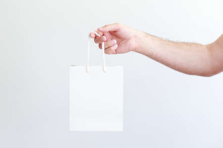 white craft bag in male handの写真素材