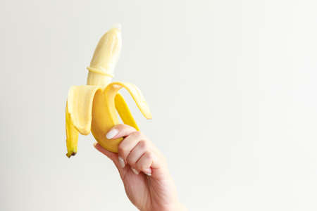 banana with a condom on a white background. contraceptives.