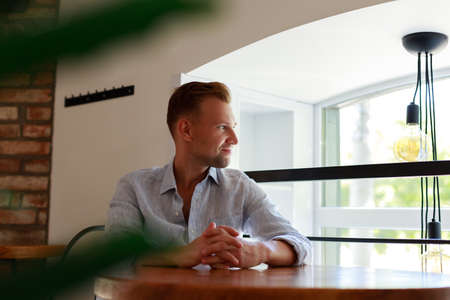 Handsome young smiling man driving a car. Happy male driver smiling while sitting in car with open front window.の写真素材