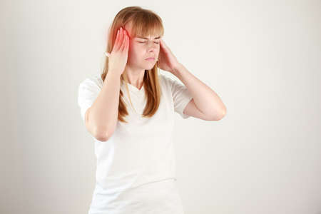 woman holding her hands to the head in pain , Young woman having severe headaches from migraines. Health and illness conceptの写真素材