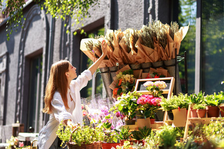 woman chooses a bouquet at the flower market outsideの写真素材