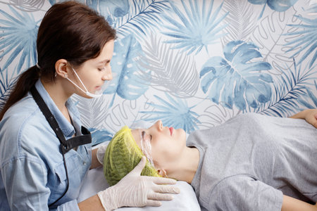 beautician and woman at the reception on the couch. skin rejuvenationの写真素材