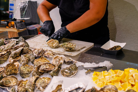 fresh oysters are sold in the market. close-up woman opens oysters in the market