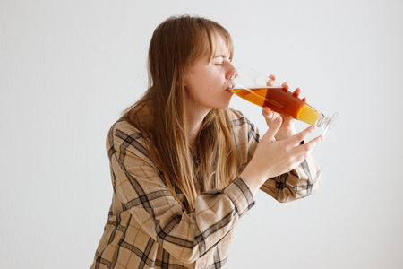 woman drinks beer on a white background. alcoholismの写真素材