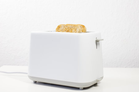 toaster with bread inside on the table. breakfast, lunch. slices of bread. toaster breadの写真素材