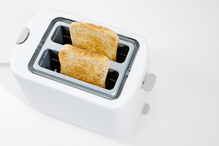 electric toaster with two toasted slices of bread on a white background