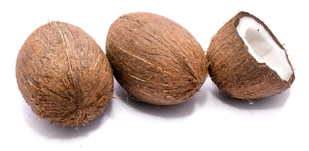 Two whole coconuts and one cracked coconut half isolated on white background
の写真素材