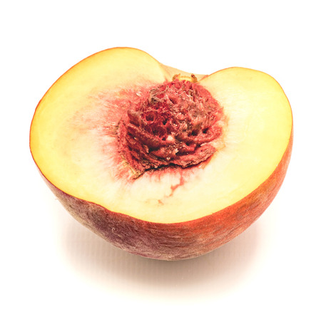 One peach half with a corrugated stone isolated on white background