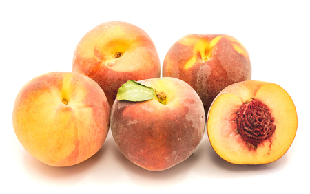 Group of whole peaches and one sliced half with a stone isolated on white background
の写真素材