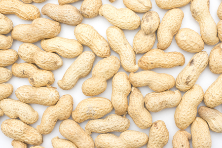 Unshelled peanuts background isolated on white top view