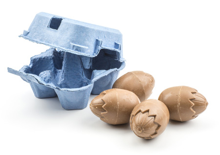 Four chocolate eggs with a blue box isolated on white background