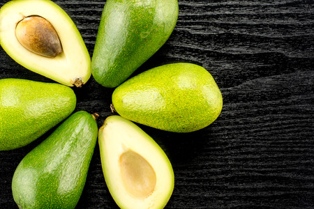 Green smooth avocado flower set table top isolated on black wood background bacon variety