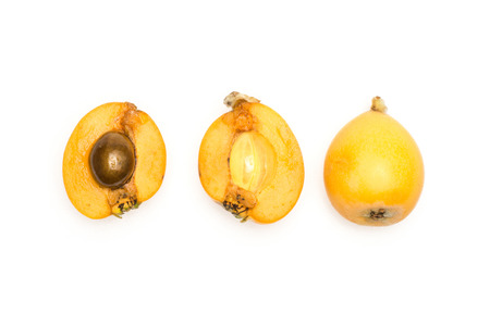 Fresh orange Japanese loquats collection top view isolated on white background one cut in two halves with a seed and wholeの写真素材