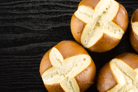 Bavarian bread buns top view on black wood background fresh baked loavesの写真素材