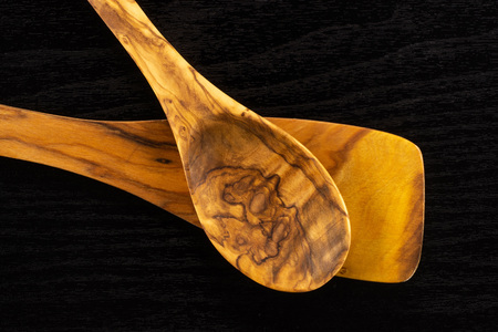 Group of two whole kitchen tool olivewood spoon and flat spatula flatlay on black woodの写真素材