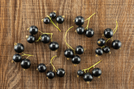 Lot of whole fresh black currant berry ben gairn variety flatlay on brown woodの写真素材