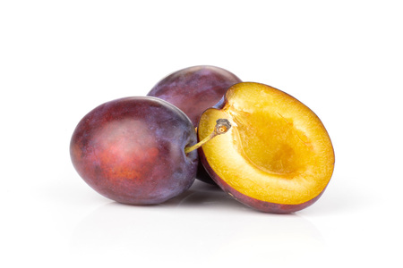 Group of two whole one half of fresh violet-blue plum vibrant moyer variety isolated on whiteの写真素材