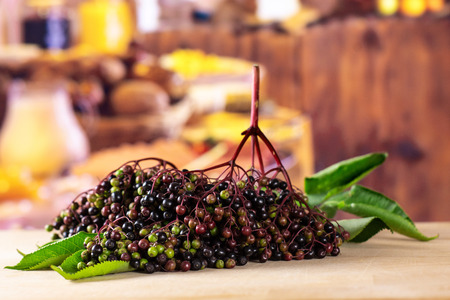 Lot of whole fresh european black elderberry with rustic wood kitchen in backgroundの写真素材