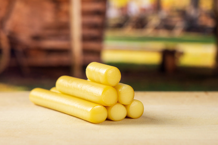 Lot of whole smoked slovak string cheese stick stack with cart in backgroundの写真素材