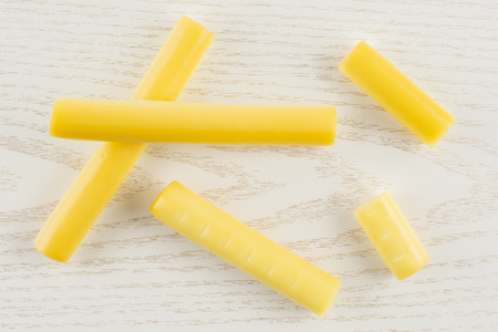 Group of five whole smoked slovak string cheese stick flatlay on grey wood