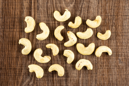 Lot of whole raw cashew nut flatlay on brown woodの写真素材