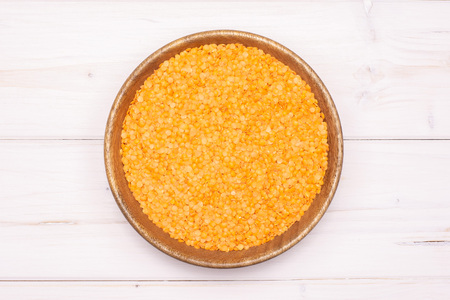 Lot of whole raw red lentils with wooden bowl flatlay on grey woodの写真素材