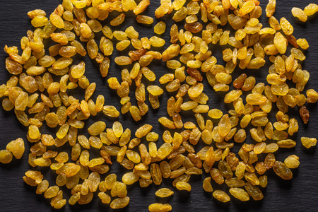 Lot of whole dry golden raisins sultana variety flatlay on grey stoneの写真素材