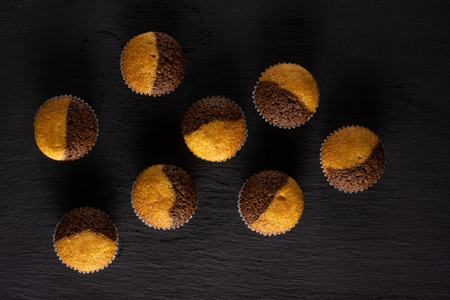 Group of eight whole fresh baked marble muffin flatlay on grey stone