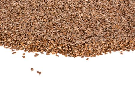 Lot of whole fresh brown flaxseeds isolated on white backgroundの写真素材