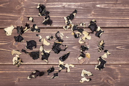Lot of slices of dry black mushroom jew ear variety flatlay on brown woodの写真素材