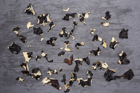Lot of slices of dry black mushroom jew ear variety flatlay on grey stoneの写真素材