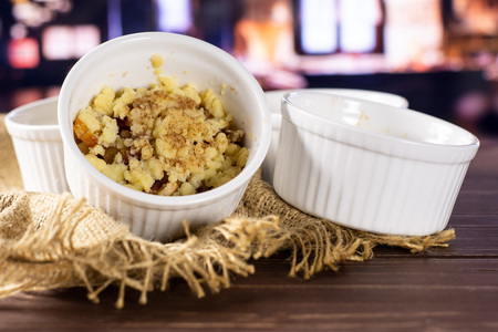 Final step. recipe step by step crumble with fruits in a ceramic ramekin with restaurant in...