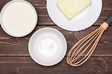 Butter and flour mixing step. recipe step by step crumble with fruits flatlay on brown woodの写真素材