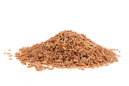 Lot of whole raw red rice stack isolated on white backgroundの写真素材
