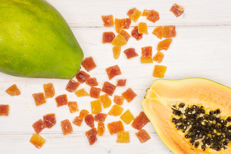 Group of one whole one half lot of slices of dry papaya flatlay on white woodの写真素材