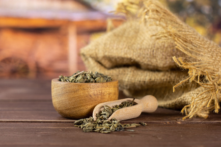 Lot of pieces of dry green tea with wooden bowl in a country yardの写真素材