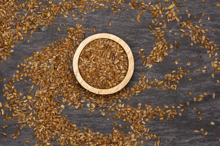 Lot of whole raw bulgur grains with wooden bowl flatlay on grey stoneの写真素材
