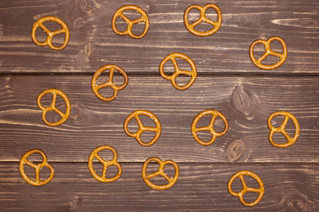 Lot of whole baked mini salted pretzels flatlay on brown woodの写真素材