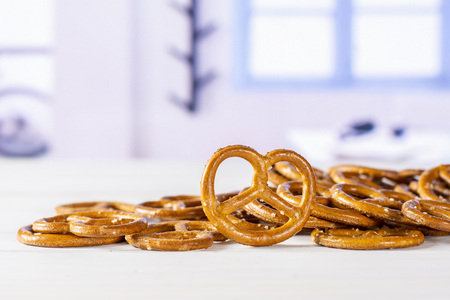 Lot of whole mini salted pretzels one is in a focus with blue windowの写真素材