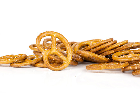 Lot of whole baked mini salted pretzels isolated on white backgroundの写真素材