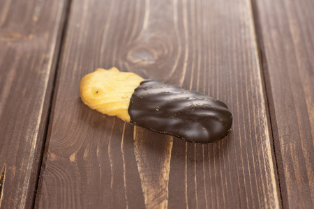 One whole lazy cookie with chocolate on brown wood