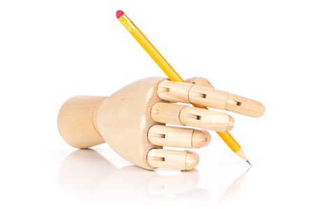 One whole yellow pencil in a wooden mannequin hand isolated on white backgroundの写真素材