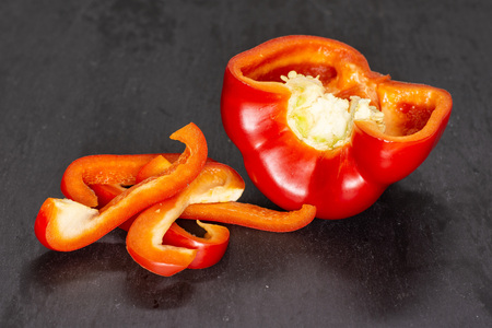 Group of one half four slices of bulgarian red bell pepper on grey stoneの写真素材
