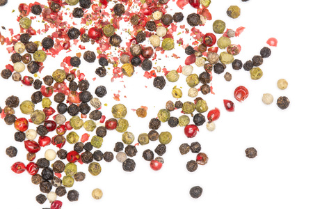 Lot of whole peppercorns of four colors flatlay isolated on white backgroundの写真素材