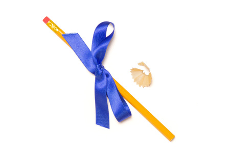 One whole yellow pencil fan-shaped shaving tied by ribbon flatlay isolated on white background