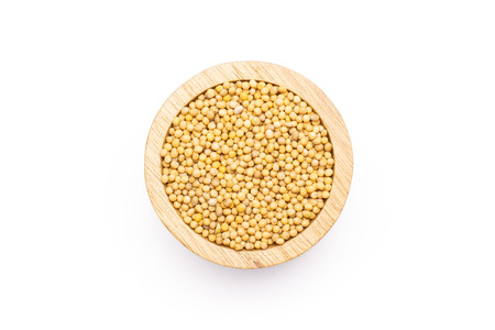 Lot of whole white mustard seeds with wooden bowl flatlay isolated on white backgroundの写真素材