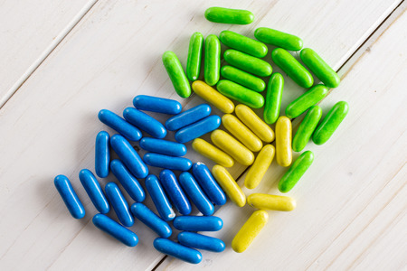 Lot of whole blue yellow and green sweet licorice comfit flatlay on white wood