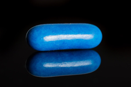 One whole blue sweet licorice comfit isolated on black glassの写真素材